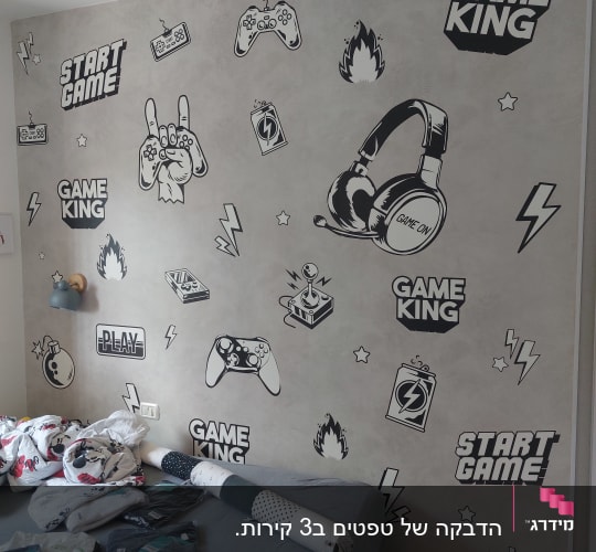 קיר עם איורים של משחקי וידאו ואוזניות